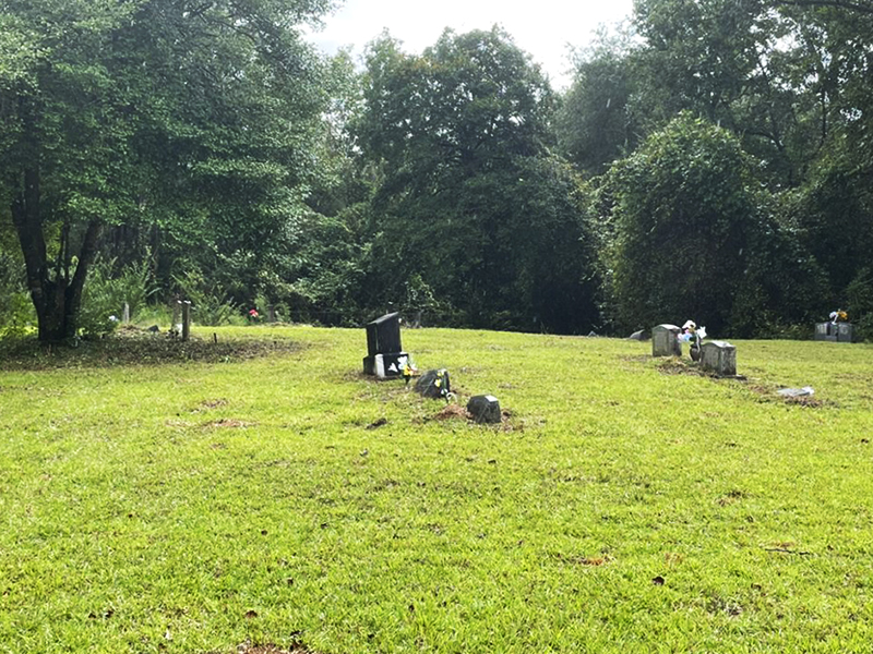 The cemetery after Alana and her family cleared the trees and mowed the grass showing headstones and memorials.