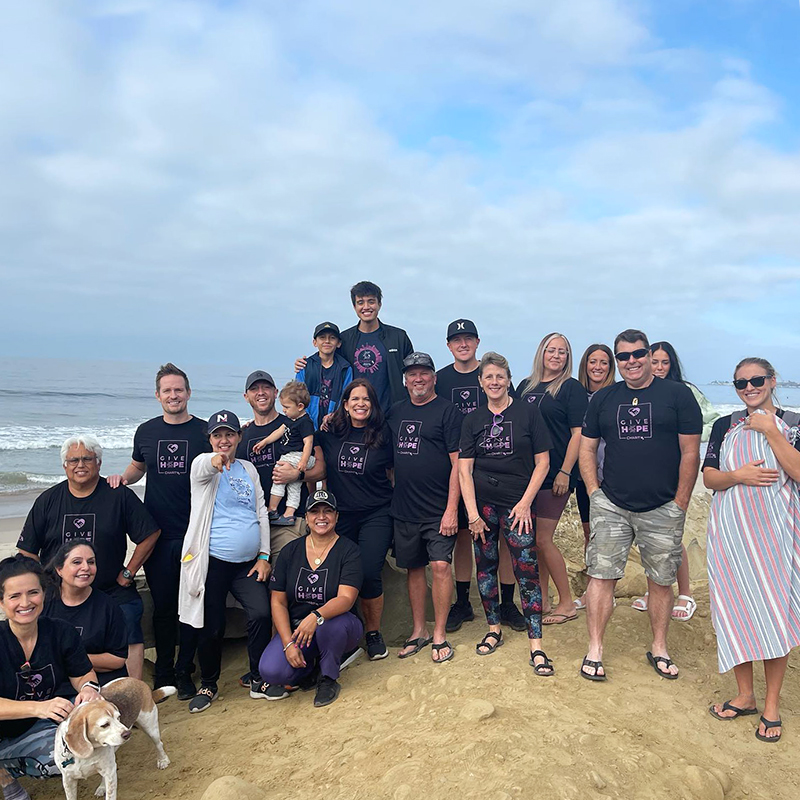 A large group of CharityRx members standing in a group on the beach