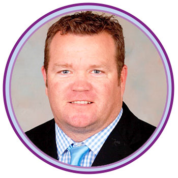 David Beckley's head shot wearing a blue suit, blue and white checkered shirt, and blue tie. 