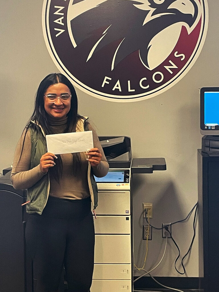 CharityRx cares about kids school lunch debt. A smiling young woman from Socorro School District in Texas is holding an envelope with a donation.