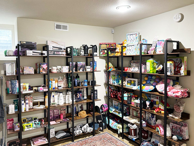 Image of a room with shelves against the walls that are stocked with household items, toys, and hygiene products.