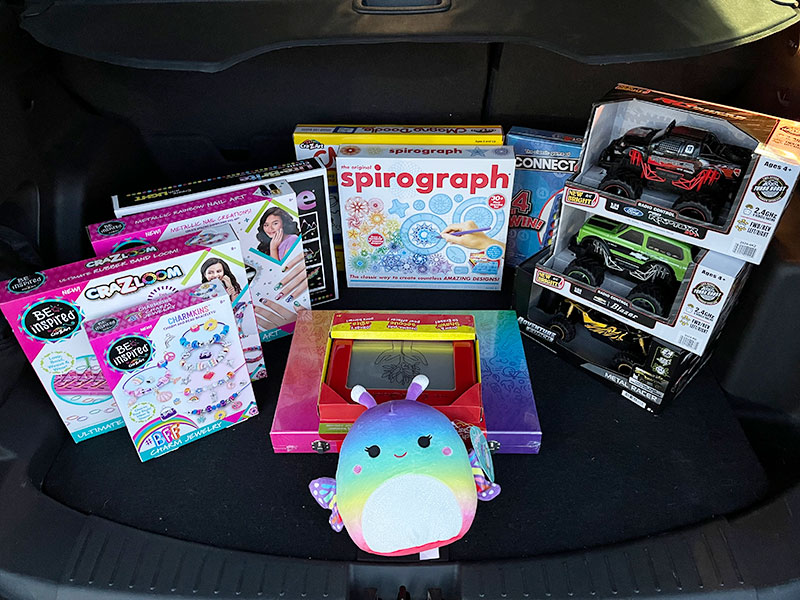 Image of toys, games, and craft kits in the trunk of a car.