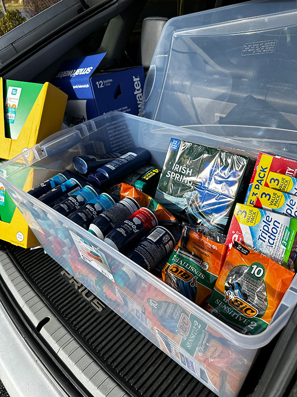 Image of a plastic bin full of hygiene items for men. CharityRx Spreading Hope Through Donations