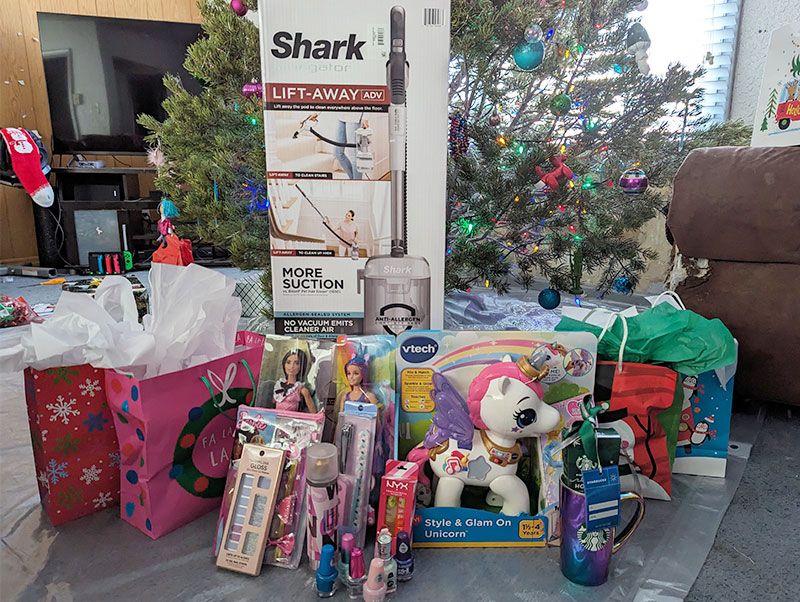 Image of a vacuum, gifts, toys, and nail polish in front of a Christmas tree. CharityRx Spreading Hope Through Donations