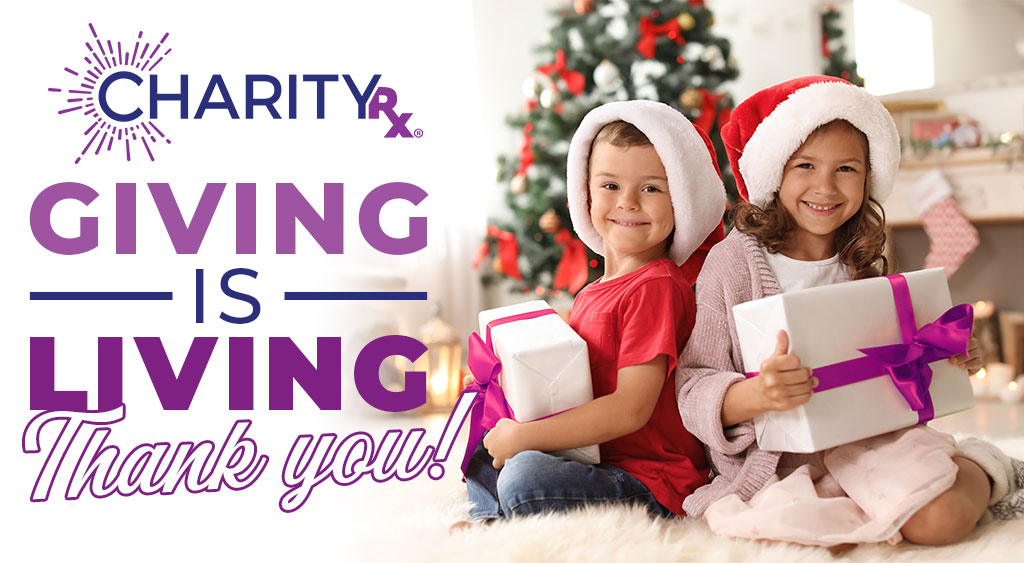 Image of two smiling children in Santa hats holding wrapped Christmas gifts. CharityRx: Spreading Hope Through Donations